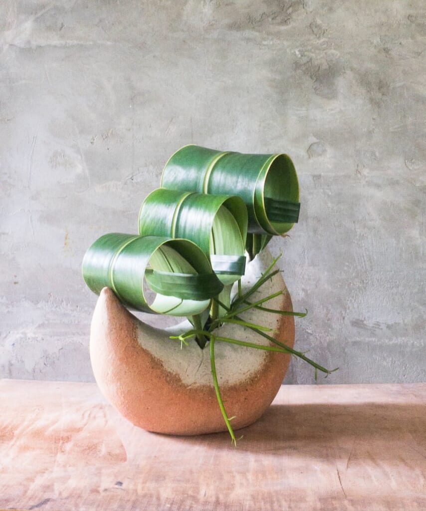 Garden leaves arranged in a moon-shaped vase