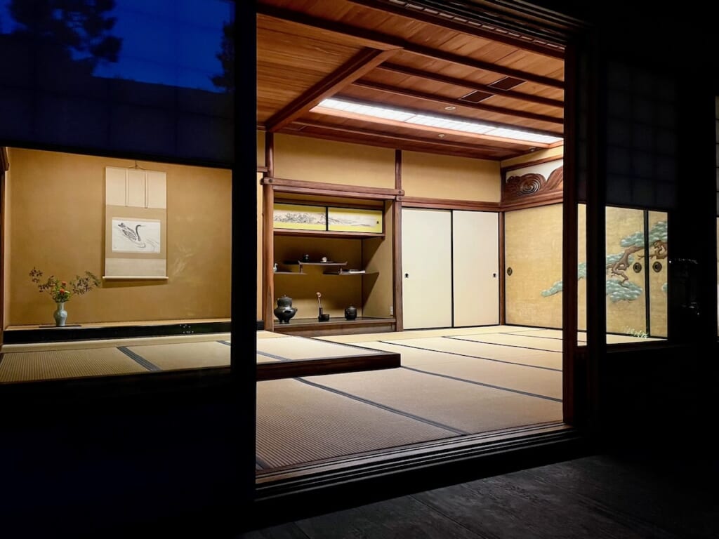 Traditional Japanese tea room with tatami, hanging scroll and seasonal arrangement