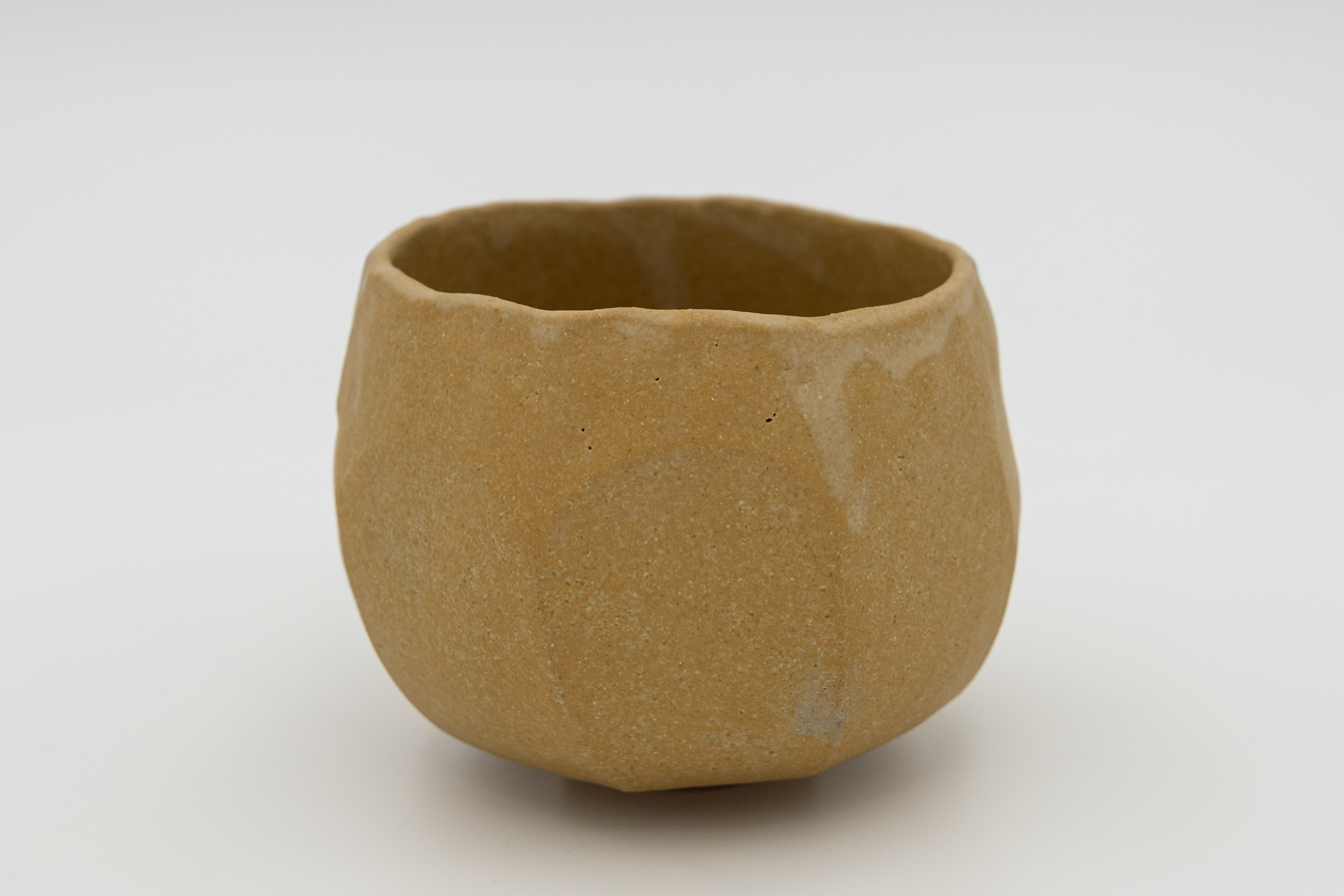 Holding, a compact ochre-glazed chawan from Seed Forms.